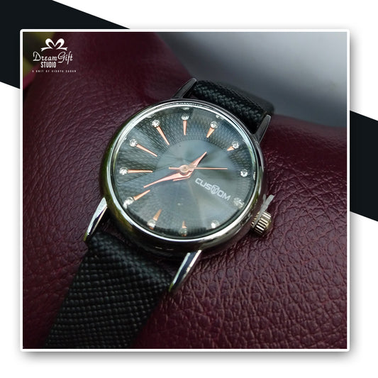 Elegant black dial with rose gold hands and crystal markers, paired with a black strap